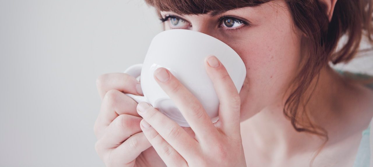 Young woman drinking tea --- Image by © Hannah Mentz/Corbis