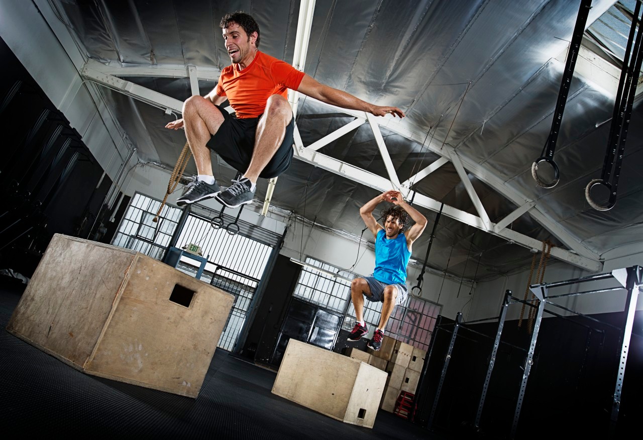 Athletes jumping in gym --- Image by © Hiya Images/Corbis